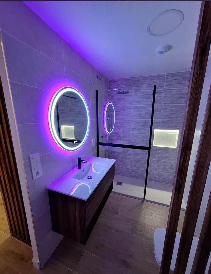 Un baño con lavabo, espejo y ducha.
