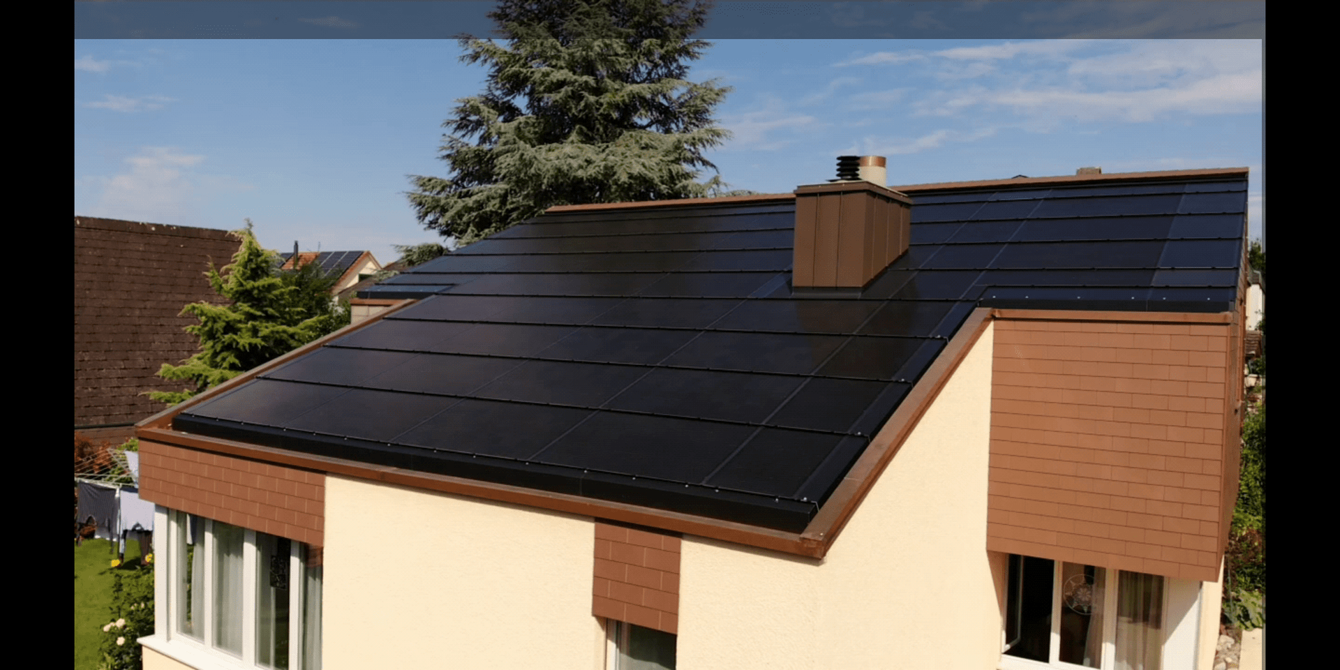 Ein Haus mit schwarzen Solarmodulen auf dem Dach