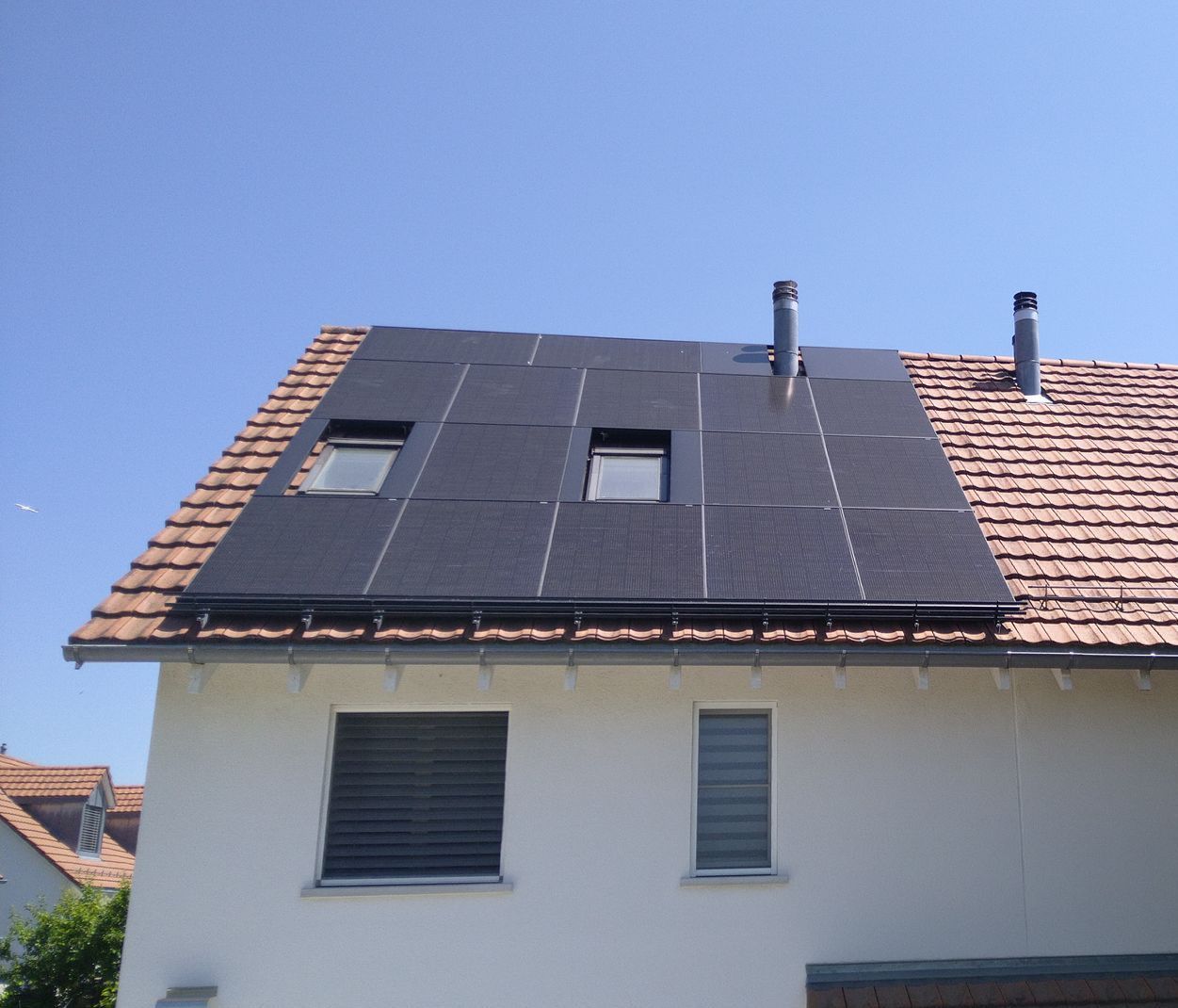 Ein weißes Haus mit Sonnenkollektoren auf dem Dach