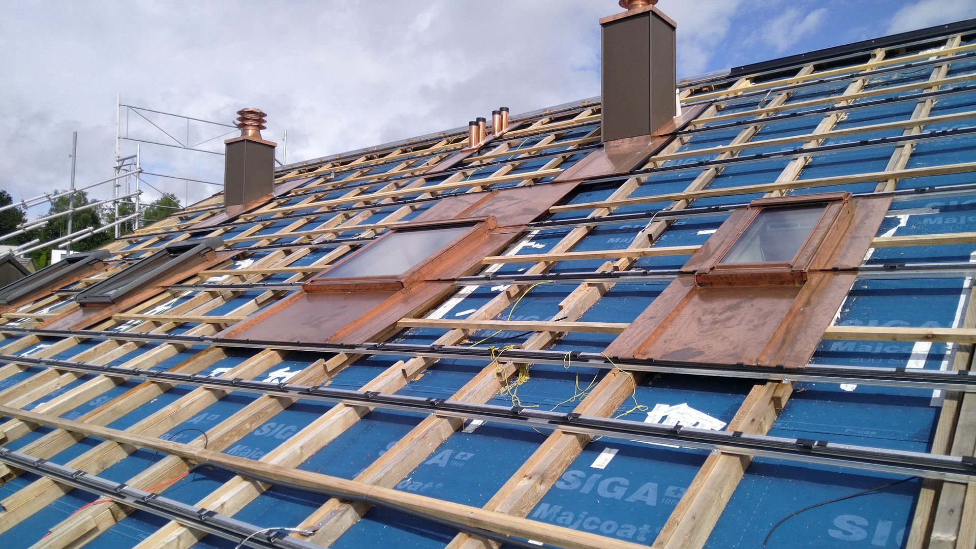 Das Dach eines Hauses wird gebaut und hat zwei Oberlichter darauf