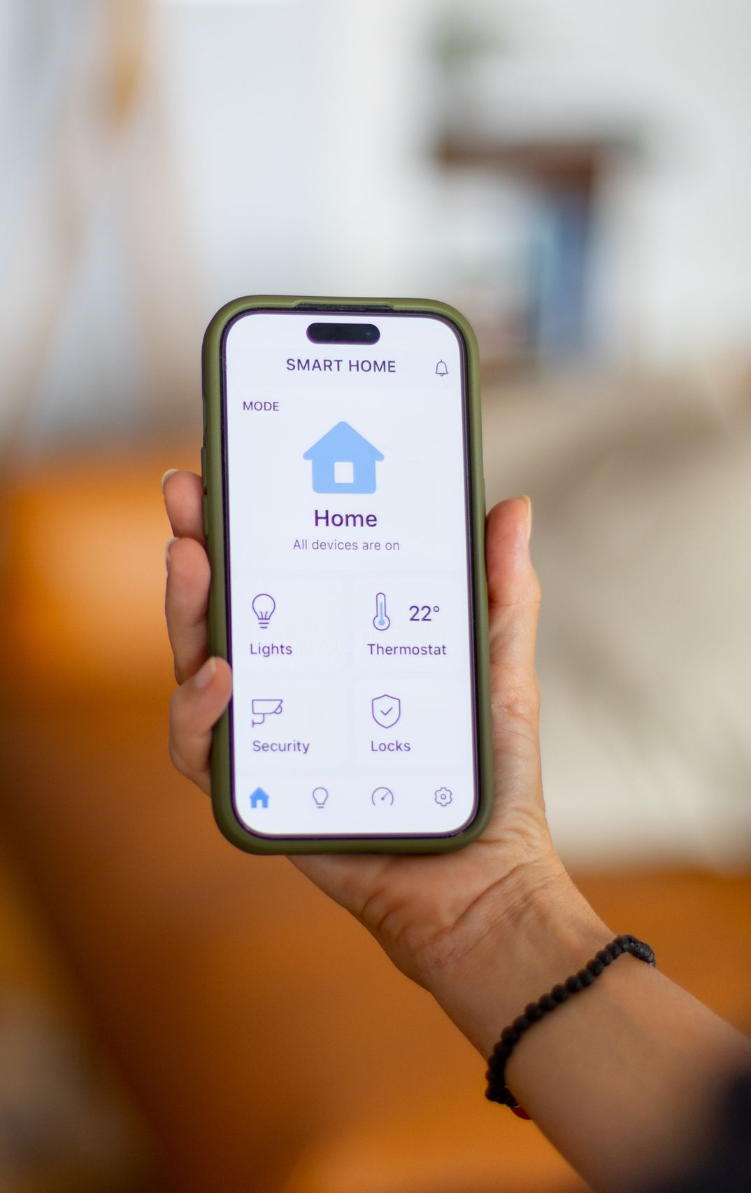 Main tenant un téléphone avec une interface d'application domotique.