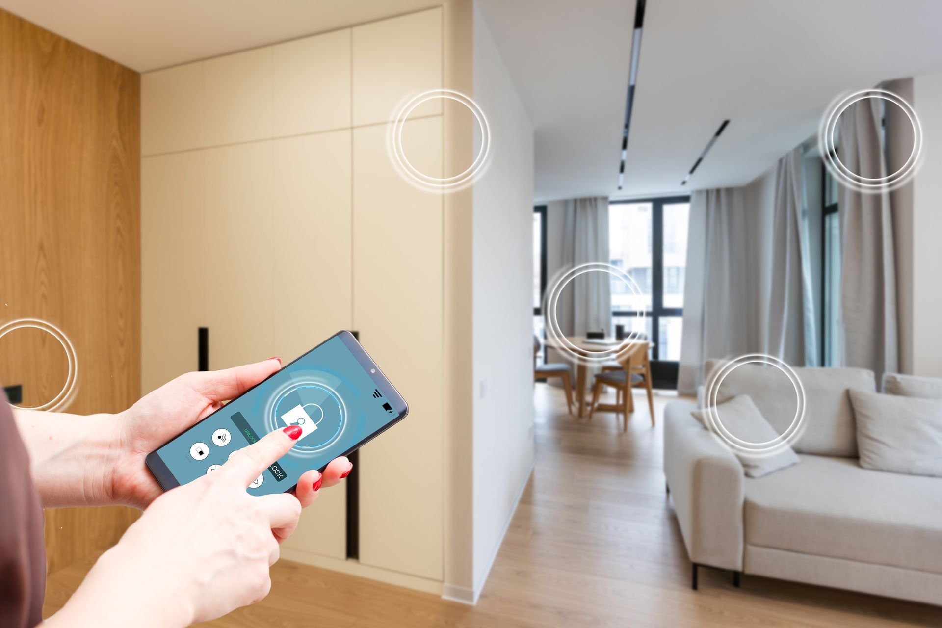 Une personne utilise un smartphone pour contrôler des appareils domotiques dans un salon moderne.