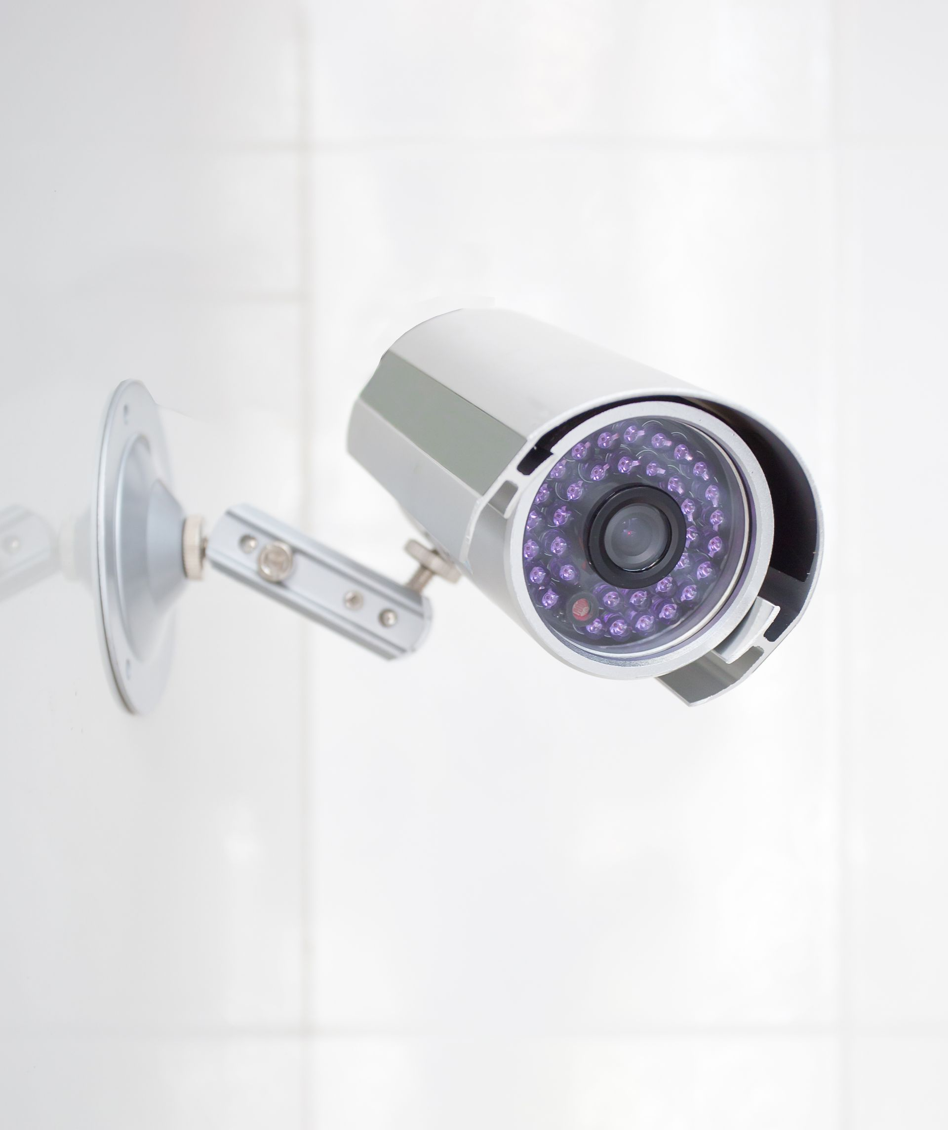 Caméra de sécurité fixée sur un mur blanc.