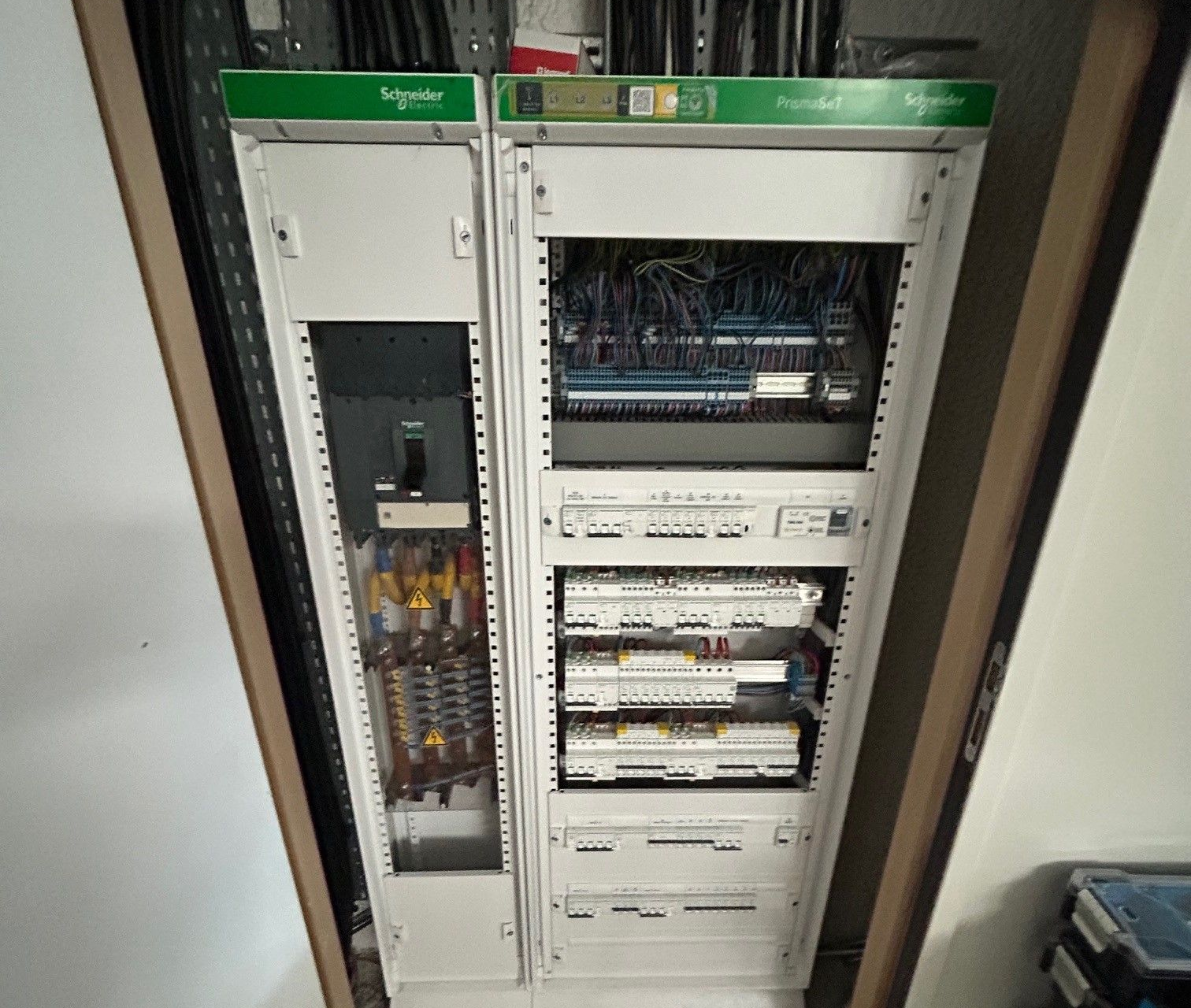 Deux armoires électriques blanches Schneider dans une pièce.