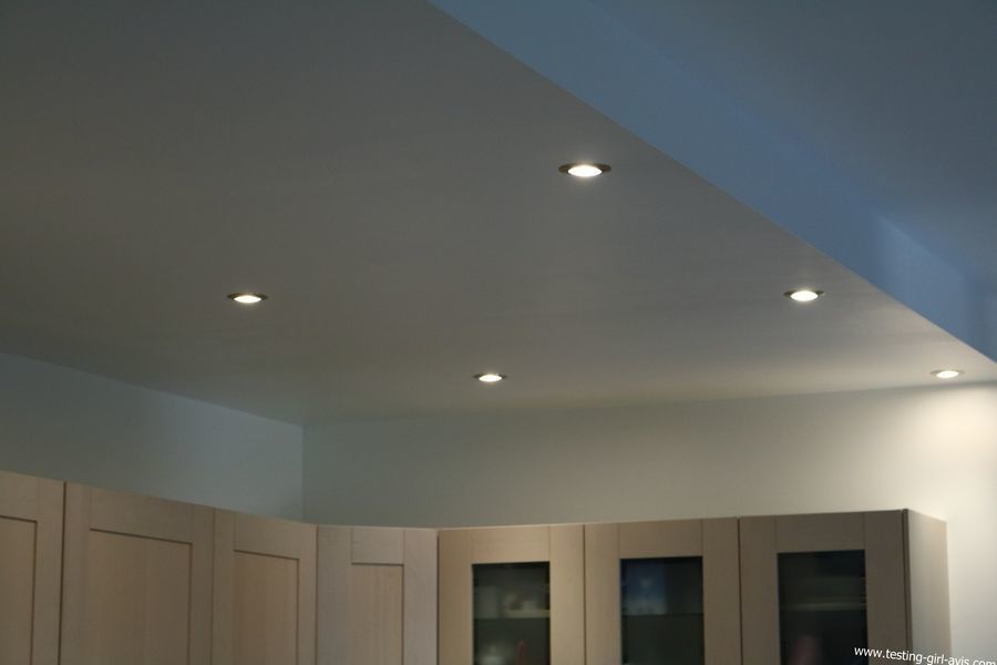 Plafond de cuisine blanc avec spots encastrés au-dessus des placards.