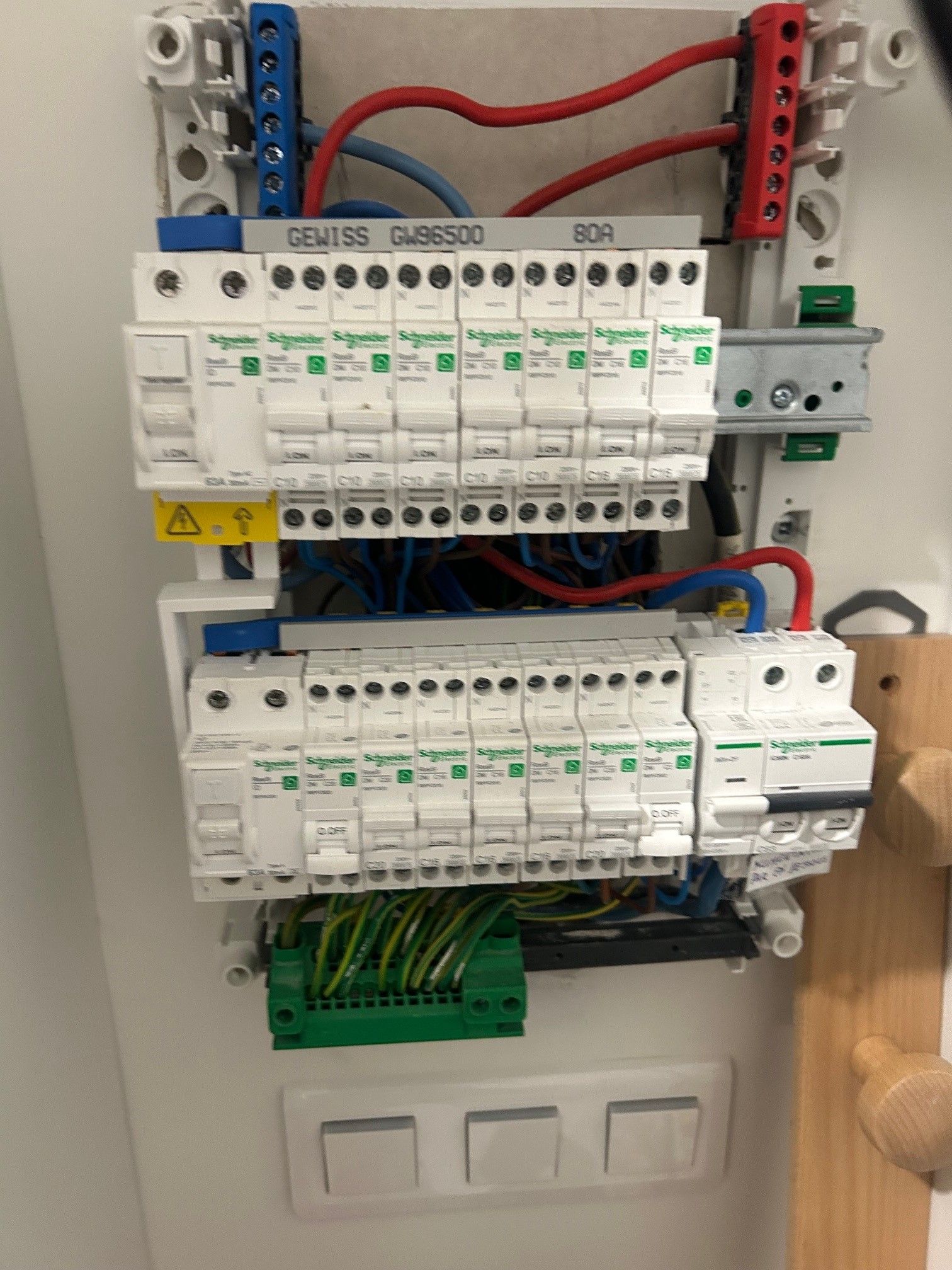 Tableau électrique avec disjoncteurs, câbles et borniers.