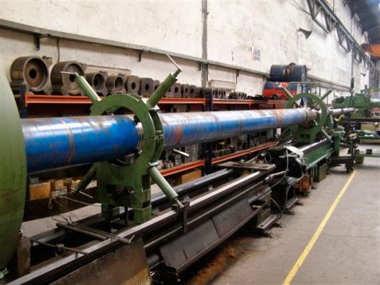 Una gran tubería azul está colocada sobre una máquina en una fábrica.