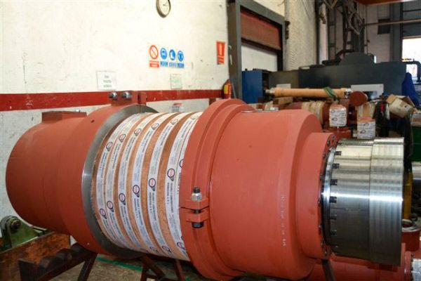 Una gran tubería roja está sobre una mesa en una fábrica.