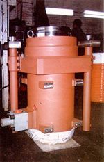 Un gran cilindro naranja está sobre una mesa en una fábrica.