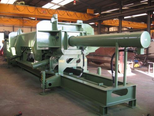 Una gran máquina verde está en un almacén.