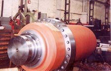 Un gran cilindro rojo está sobre una mesa de madera en una fábrica.