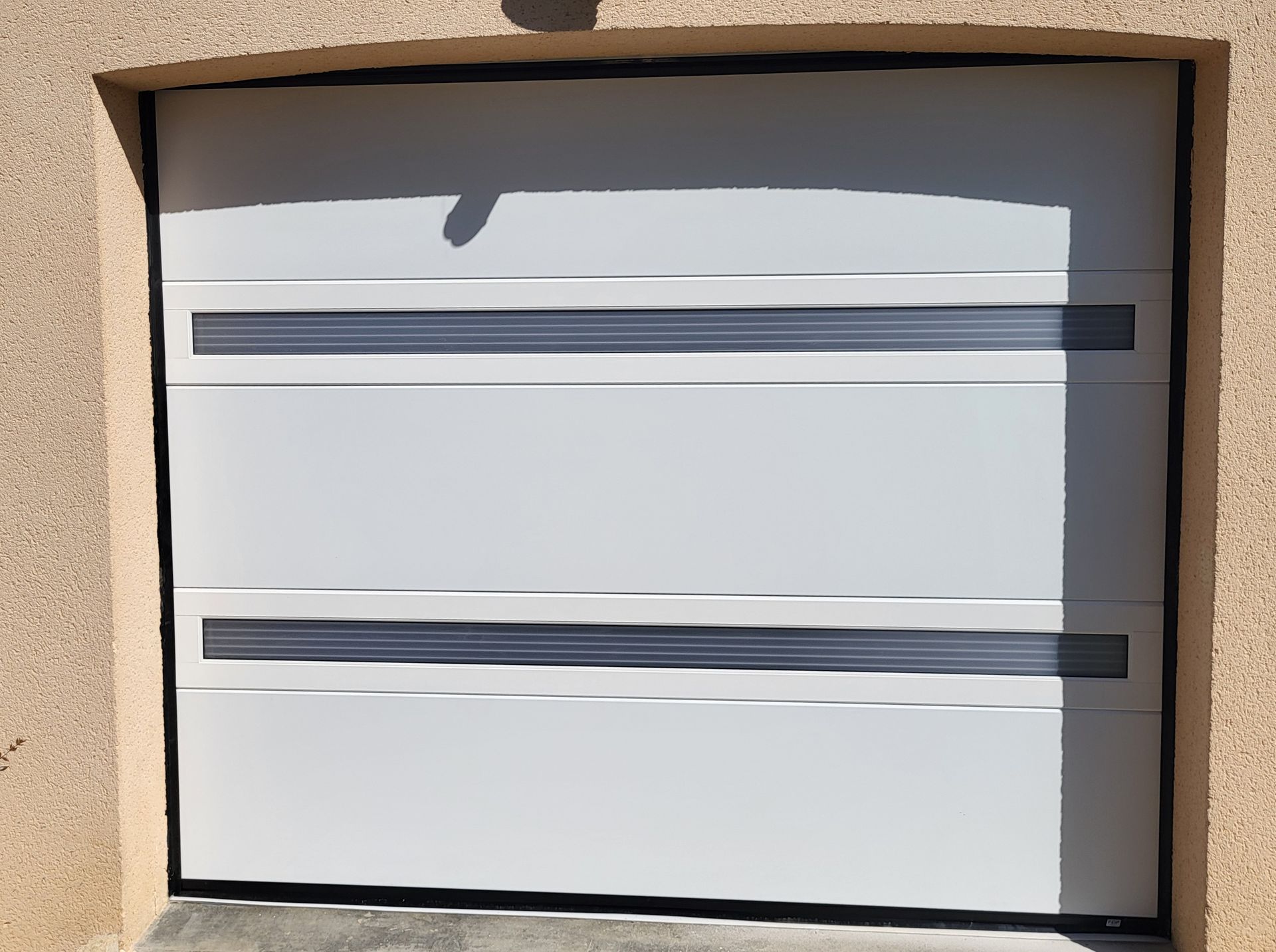 Porte de garage coulissante blanche fermée.
