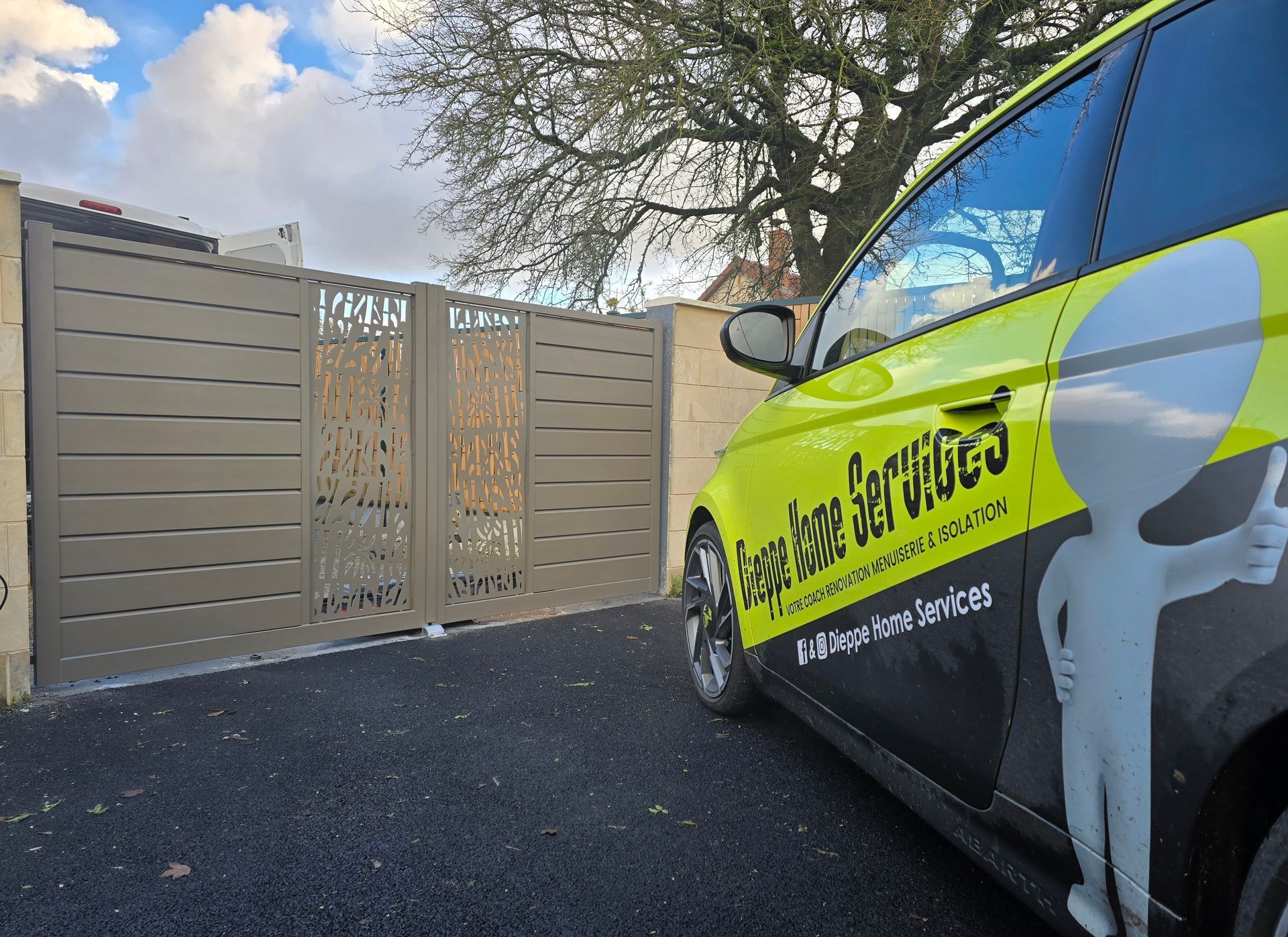 Véhicule de l'entreprise Dieppe Home Services garé devant un portail.