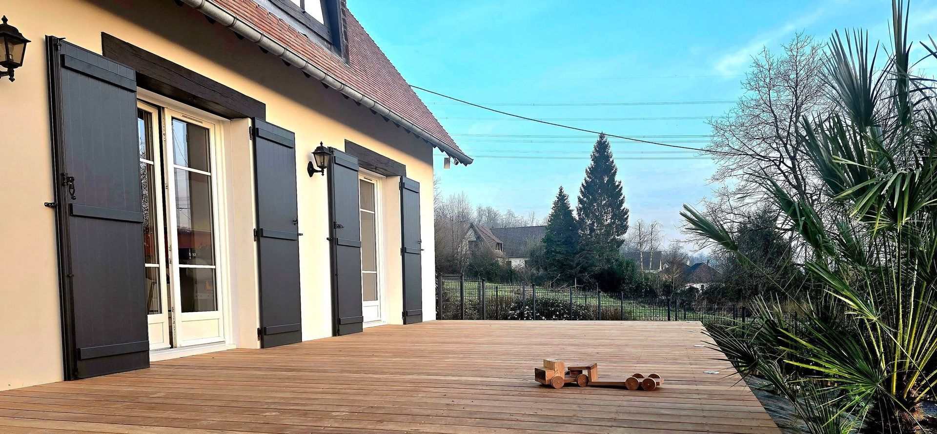 Grande terrasse en bois de couleur brun clair d'une habitation.