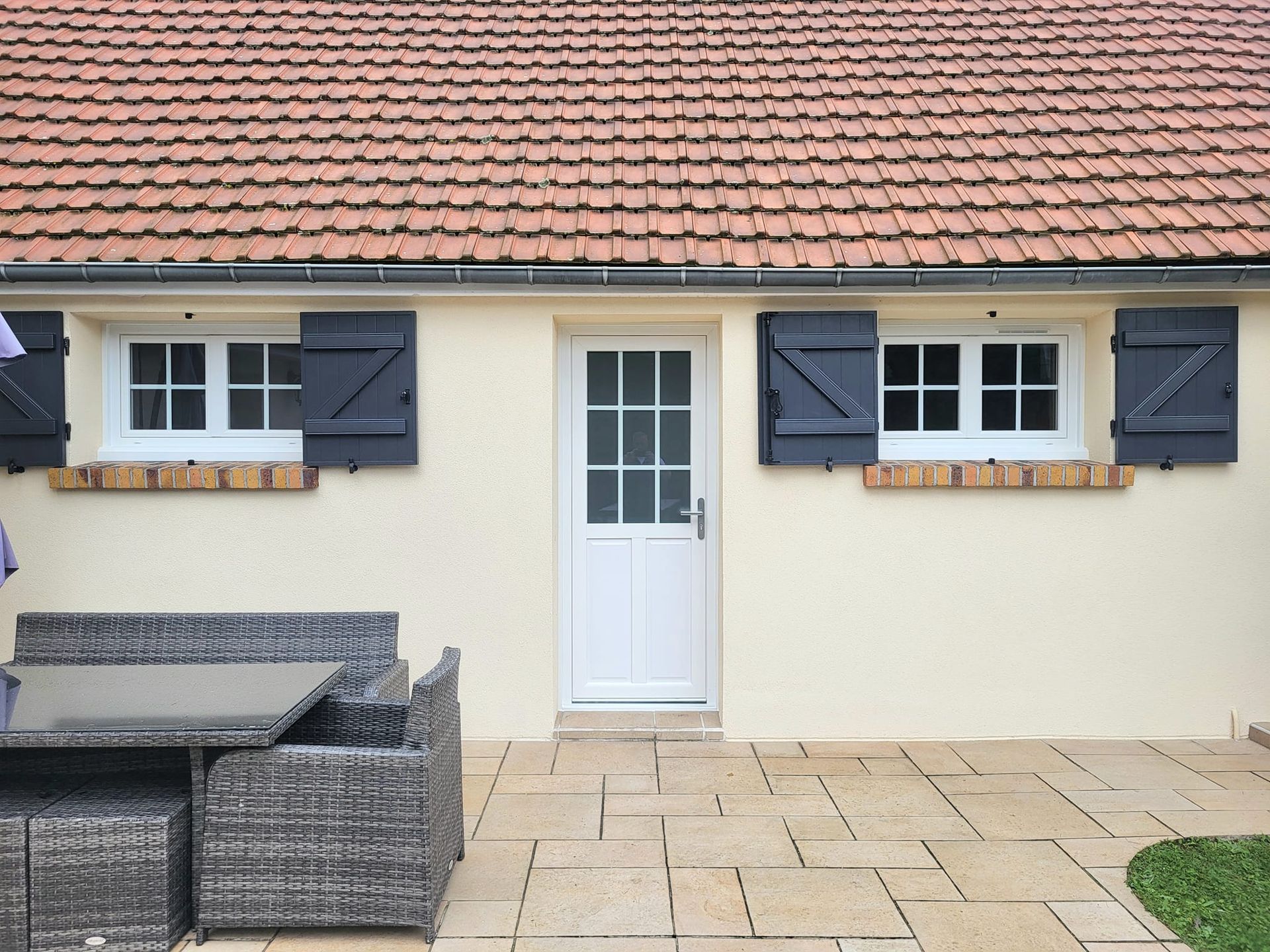 Porte d'entrée blanche d'une maison de plain-pied.