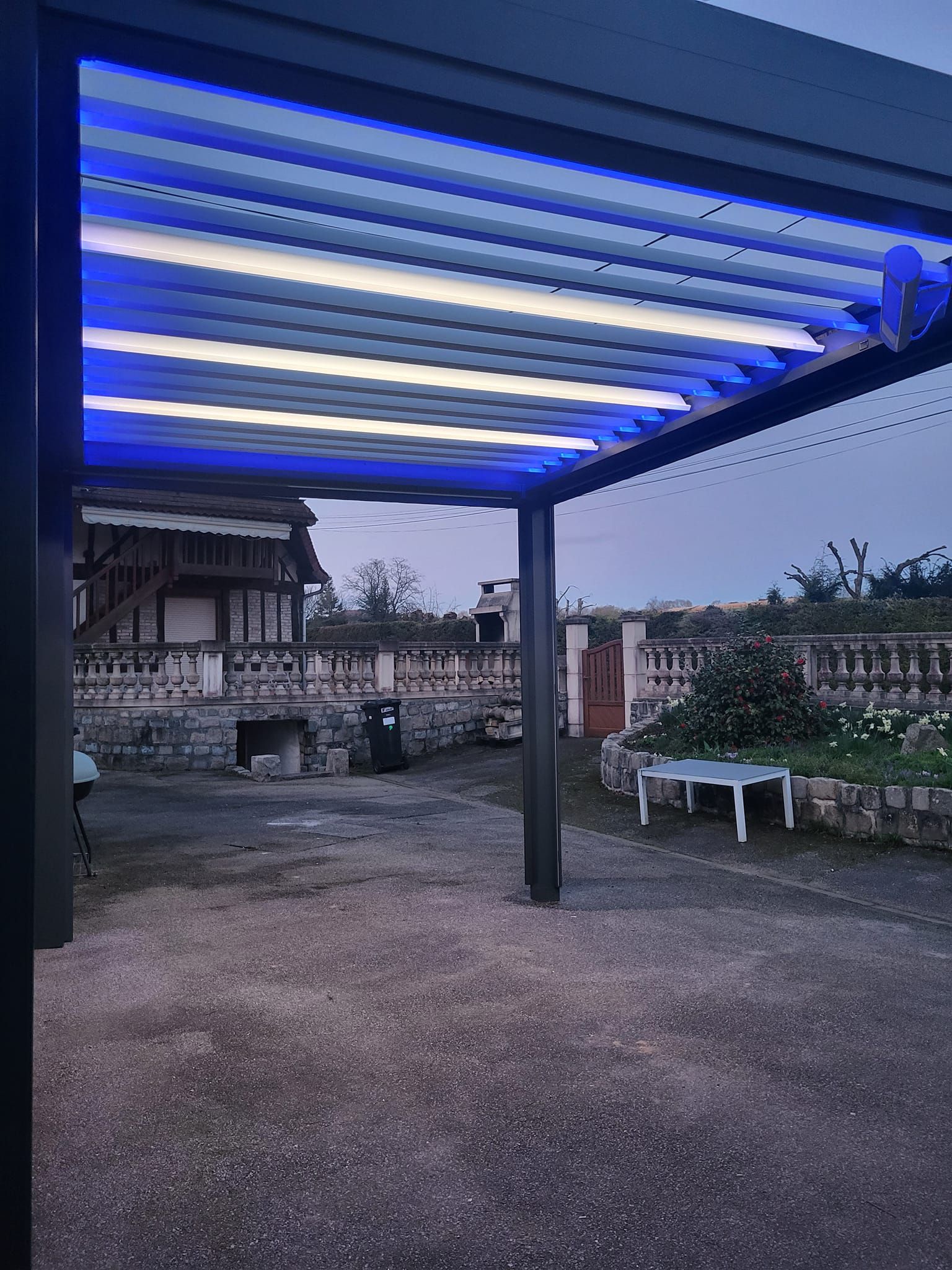 Lumières bleutées éclairant le dessous d'un carport.