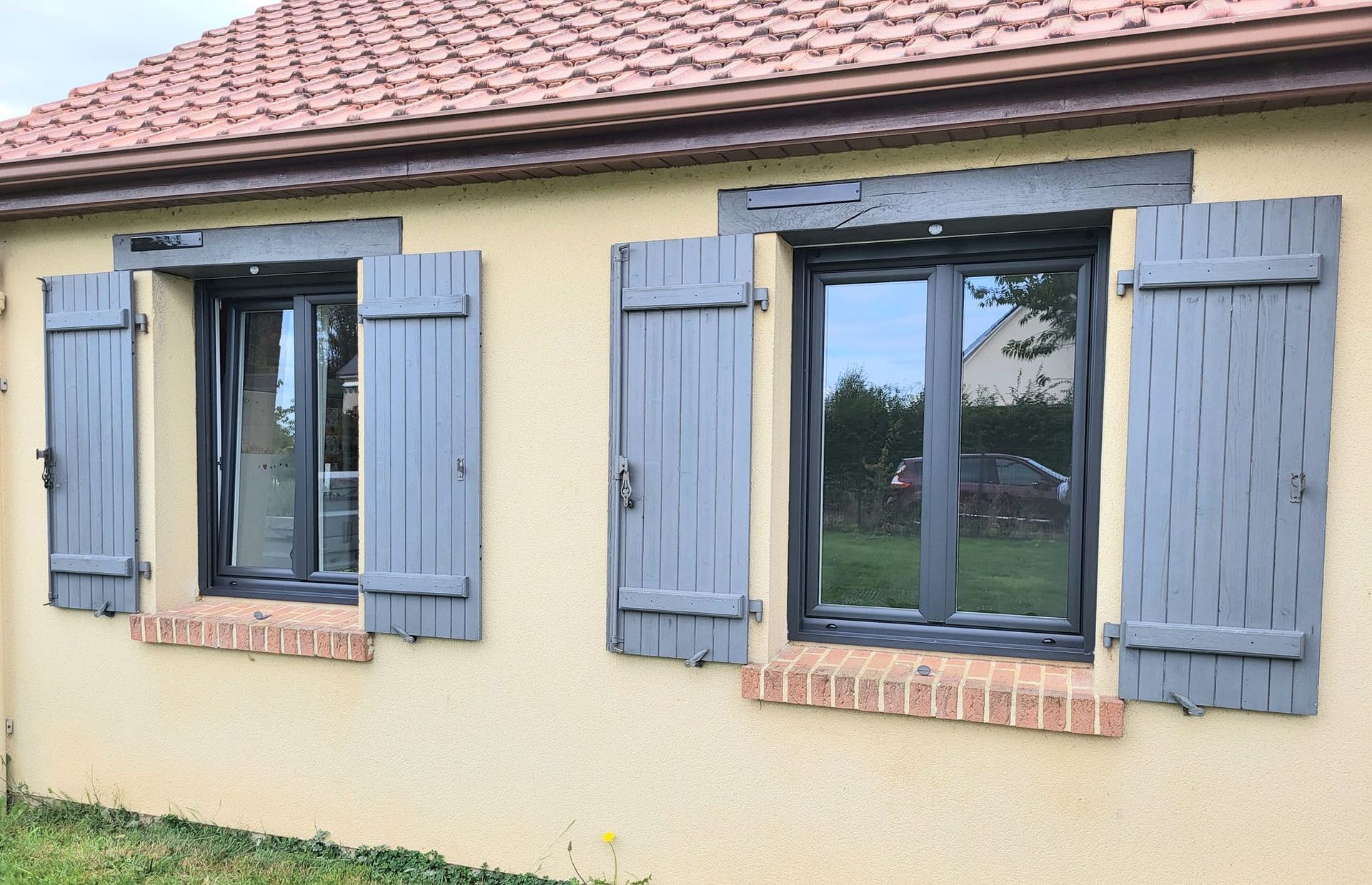 Deux fenêtres avec des volets bleu ciel.