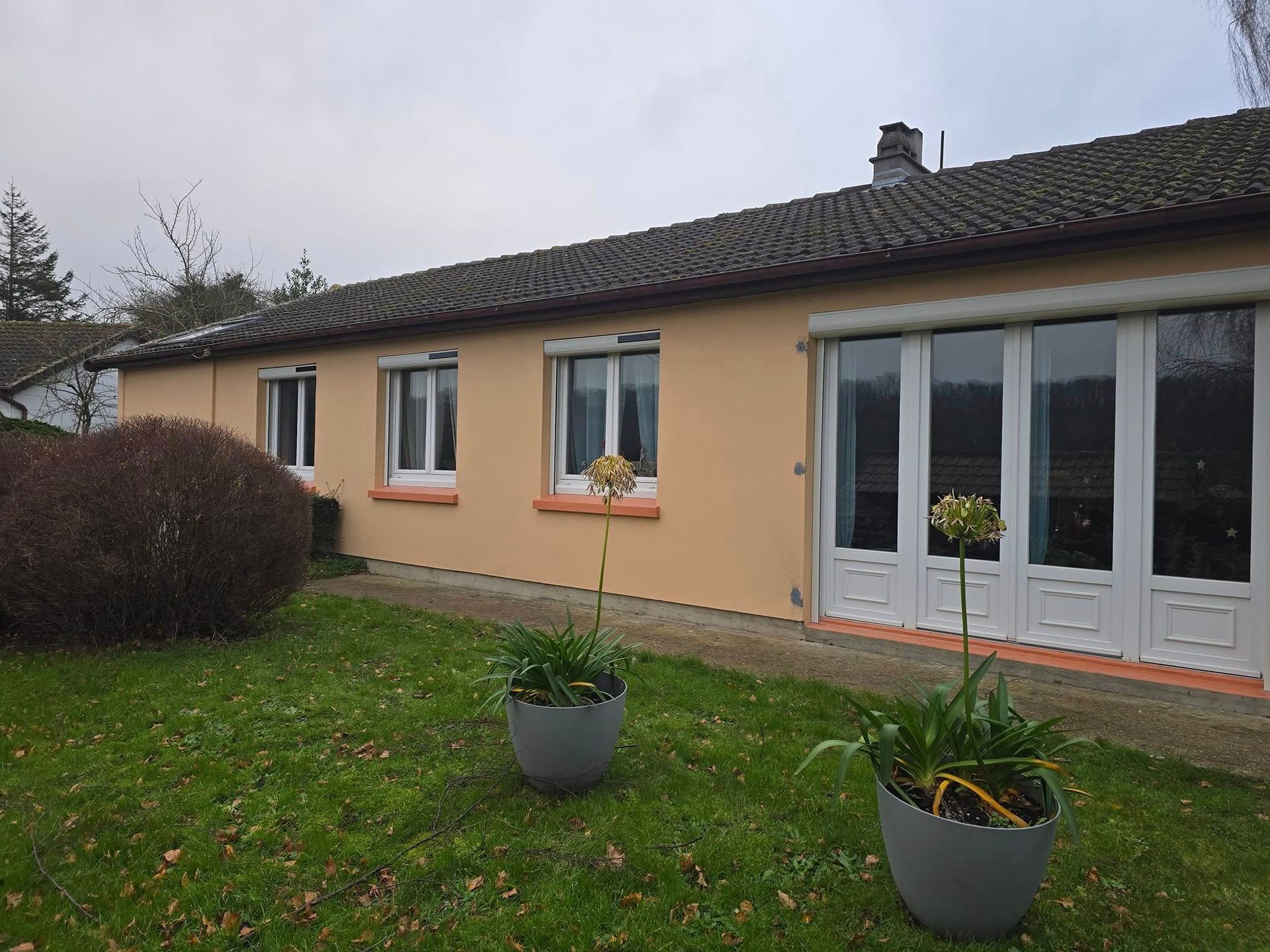 Fenêtres et porte-fenêtre blanche d'une maison de plain-pied.