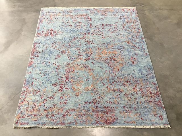 Un primer plano de una alfombra colorida con flecos sobre una mesa.