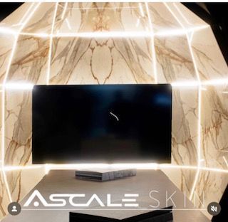 Un televisor Sky a escala está sobre una mesa frente a una pared de mármol.