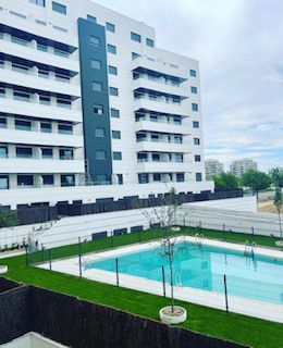 Un gran edificio con una piscina en frente.