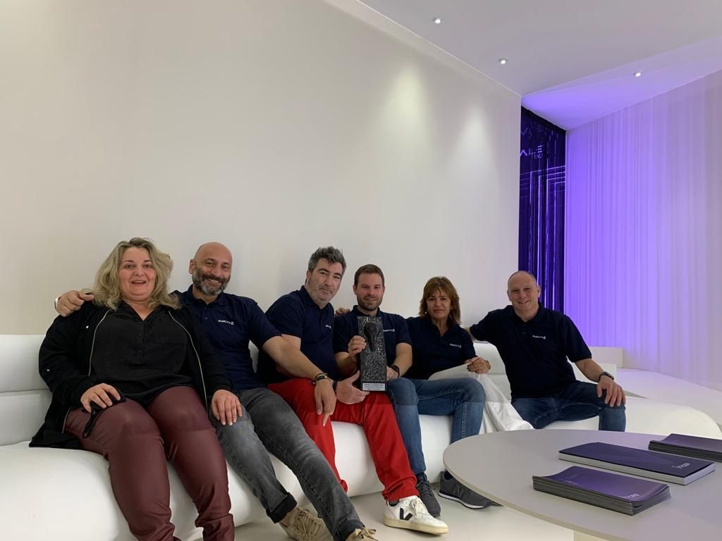 Un grupo de personas están sentadas en un sofá posando para una fotografía.