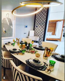 Una mesa de comedor con platos y vasos sobre ella.