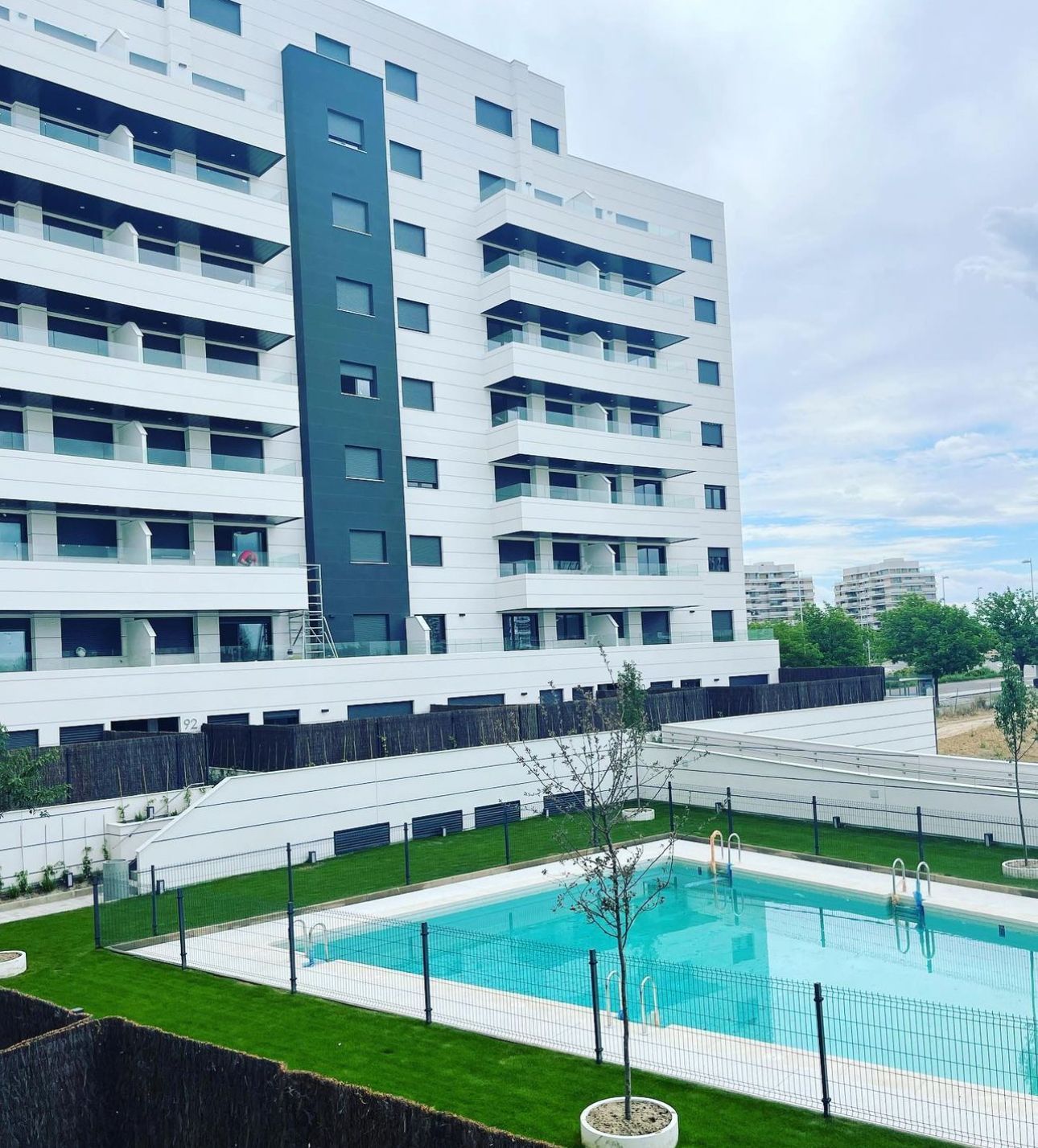 Un gran edificio con una piscina en frente.