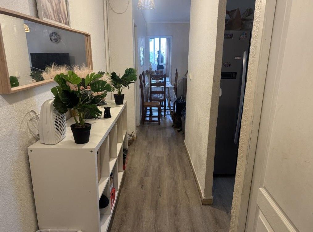 Entrée et couloir avec meuble blanc sur la gauche