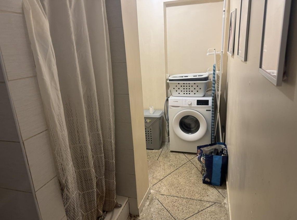 Vue sur une machine à laver dans la salle de bains d'un appartement T4 à Marseille