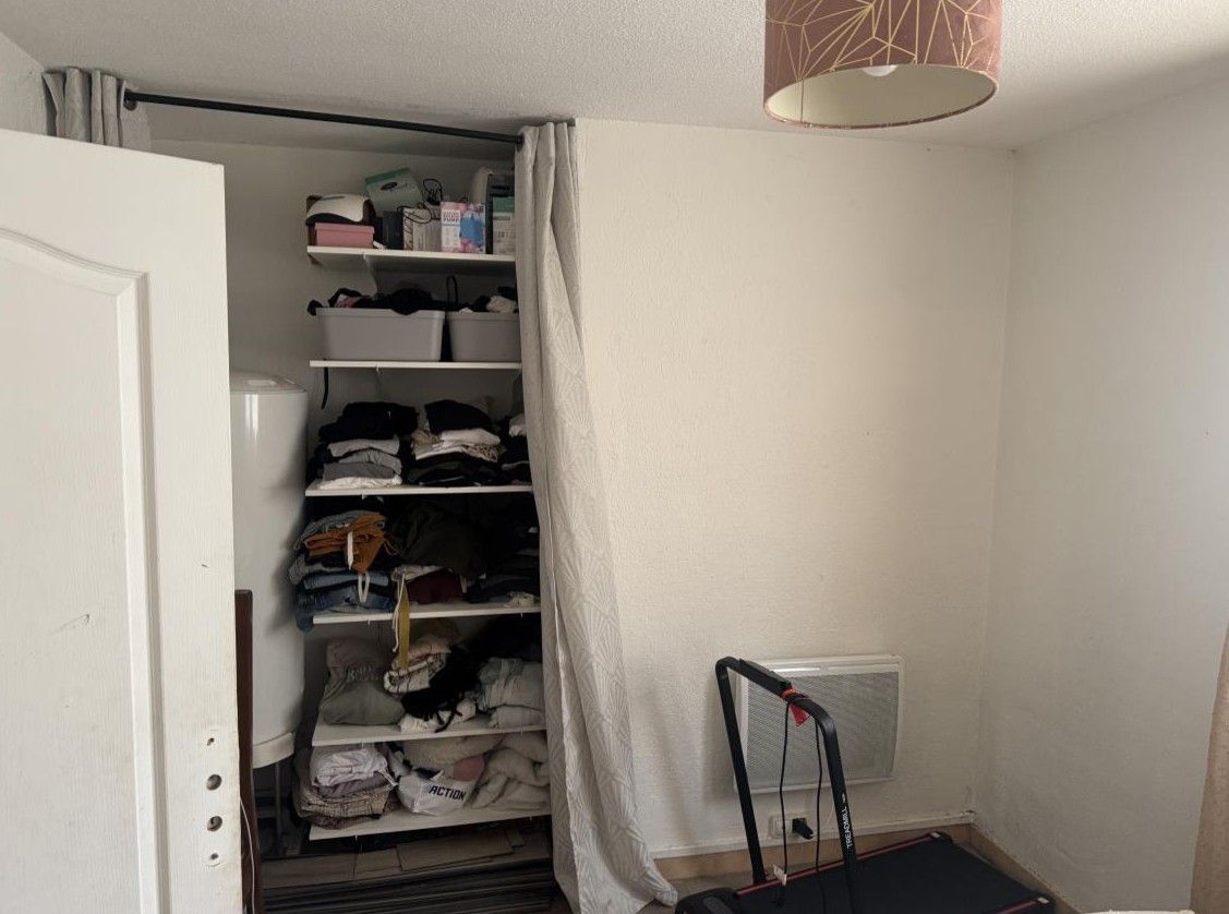 Chambre avec étagères de rangement et tapis de course