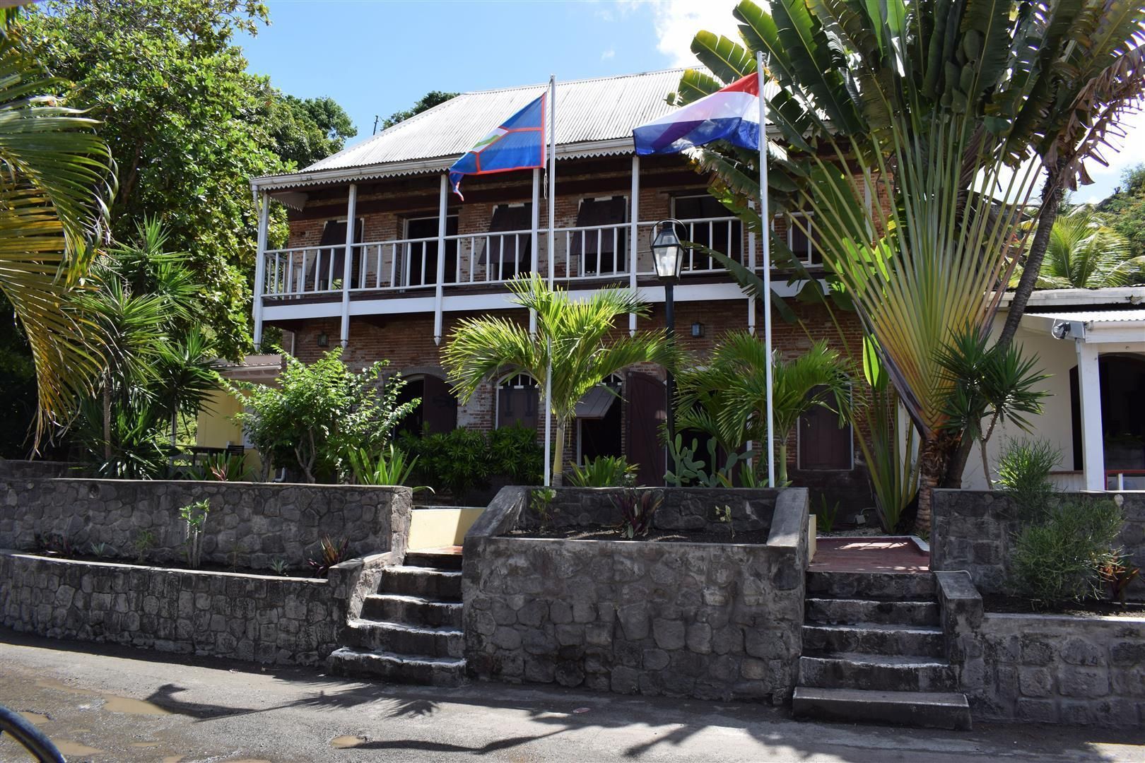 Een groot gebouw met trappen en vlaggen ervoor