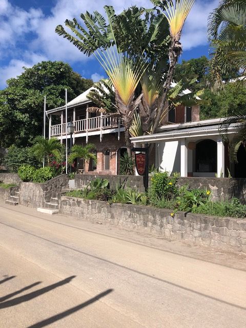 Een groot huis met een palmboom ervoor