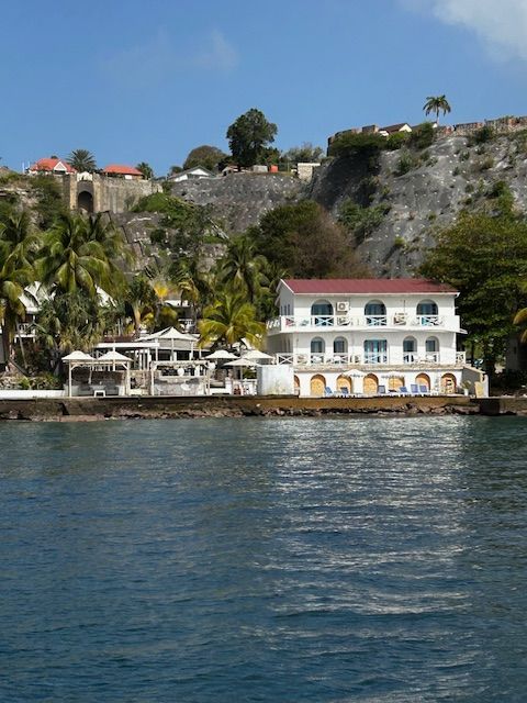 Een groot wit gebouw met een rood dak staat midden in een watermassa