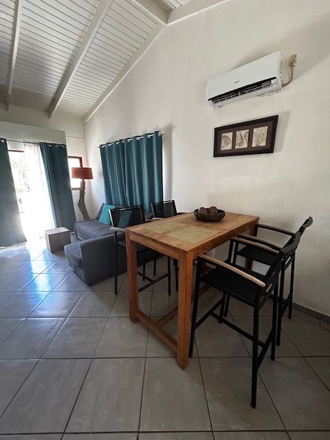 Een woonkamer met een tafel, stoelen en een bank