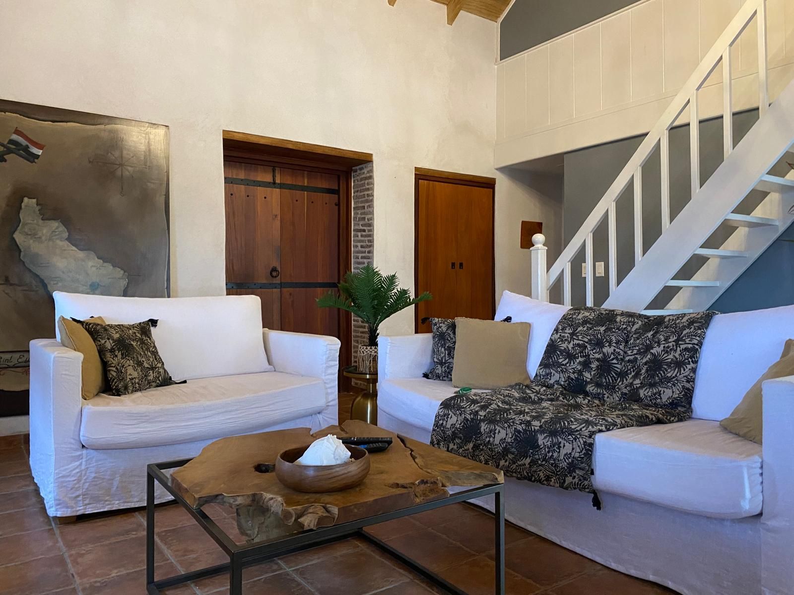 Een woonkamer met twee banken, een salontafel en een trap.