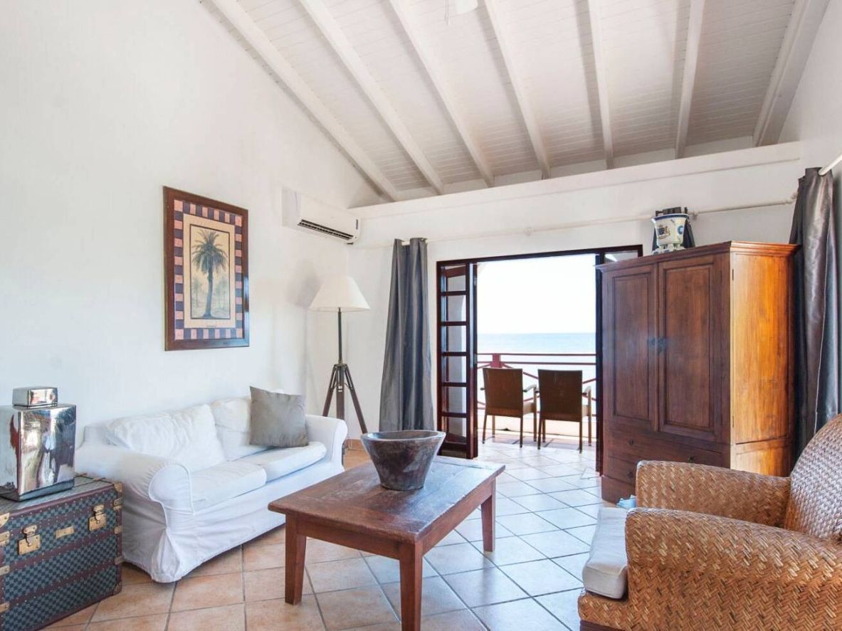 Een woonkamer met een bank, stoelen en een tafel