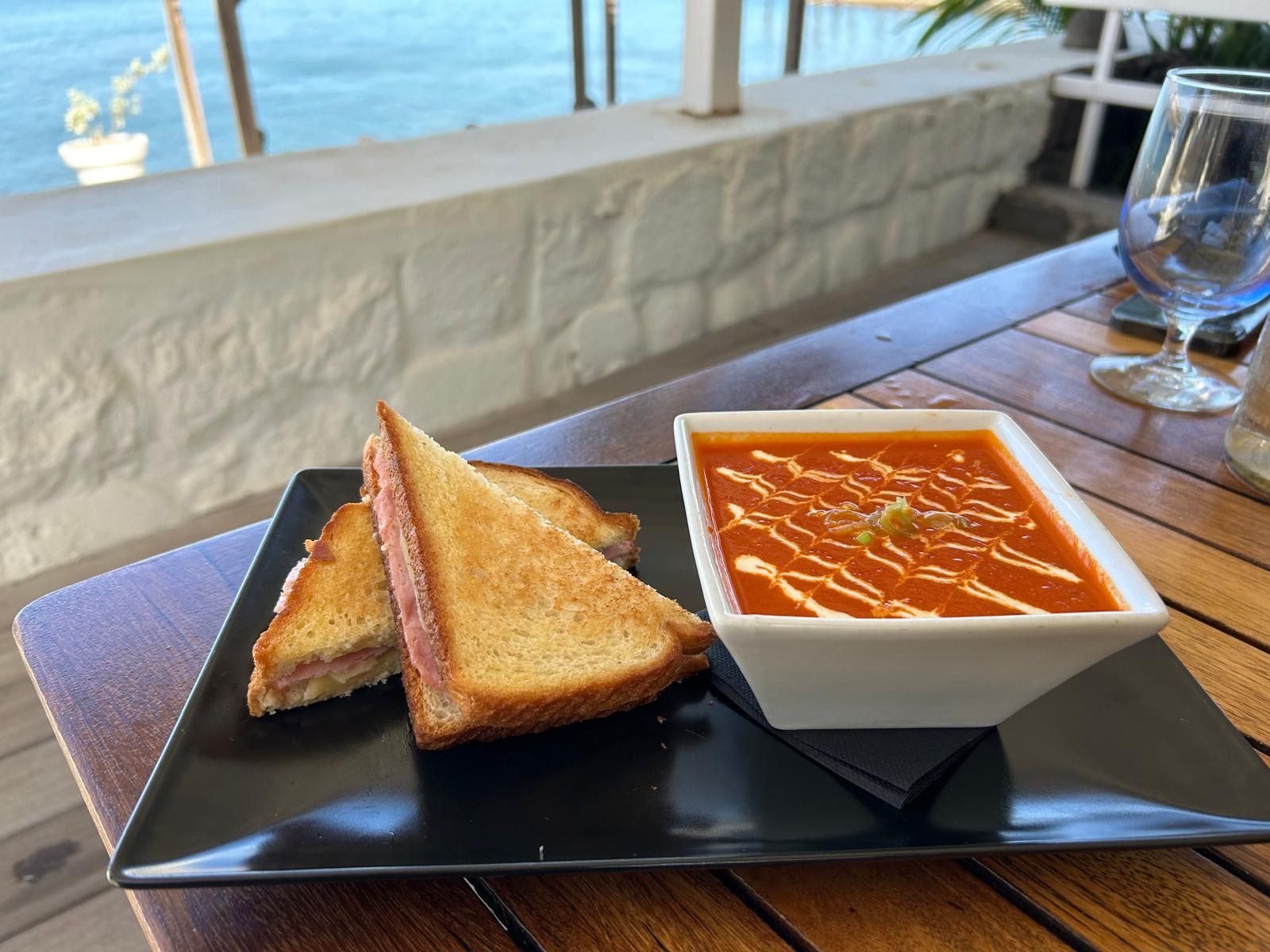 Een kom soep en twee sneetjes toast op een bord