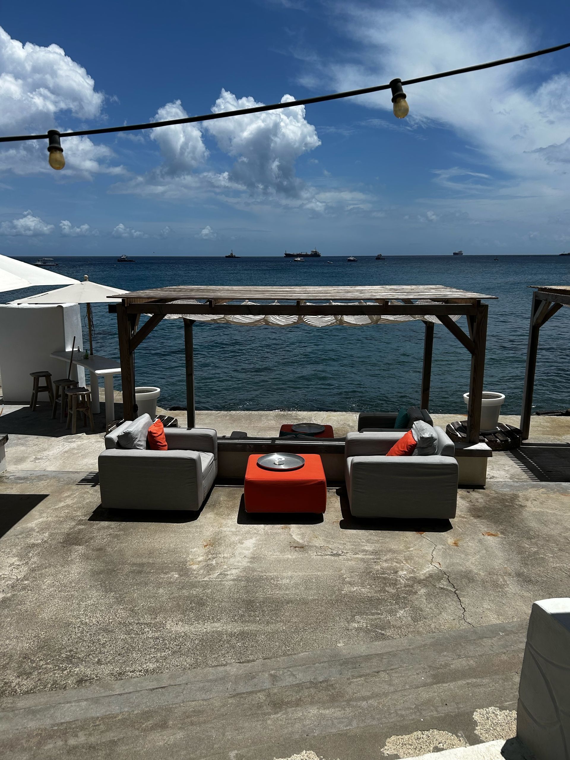 Een patio met een pergola met uitzicht op de oceaan