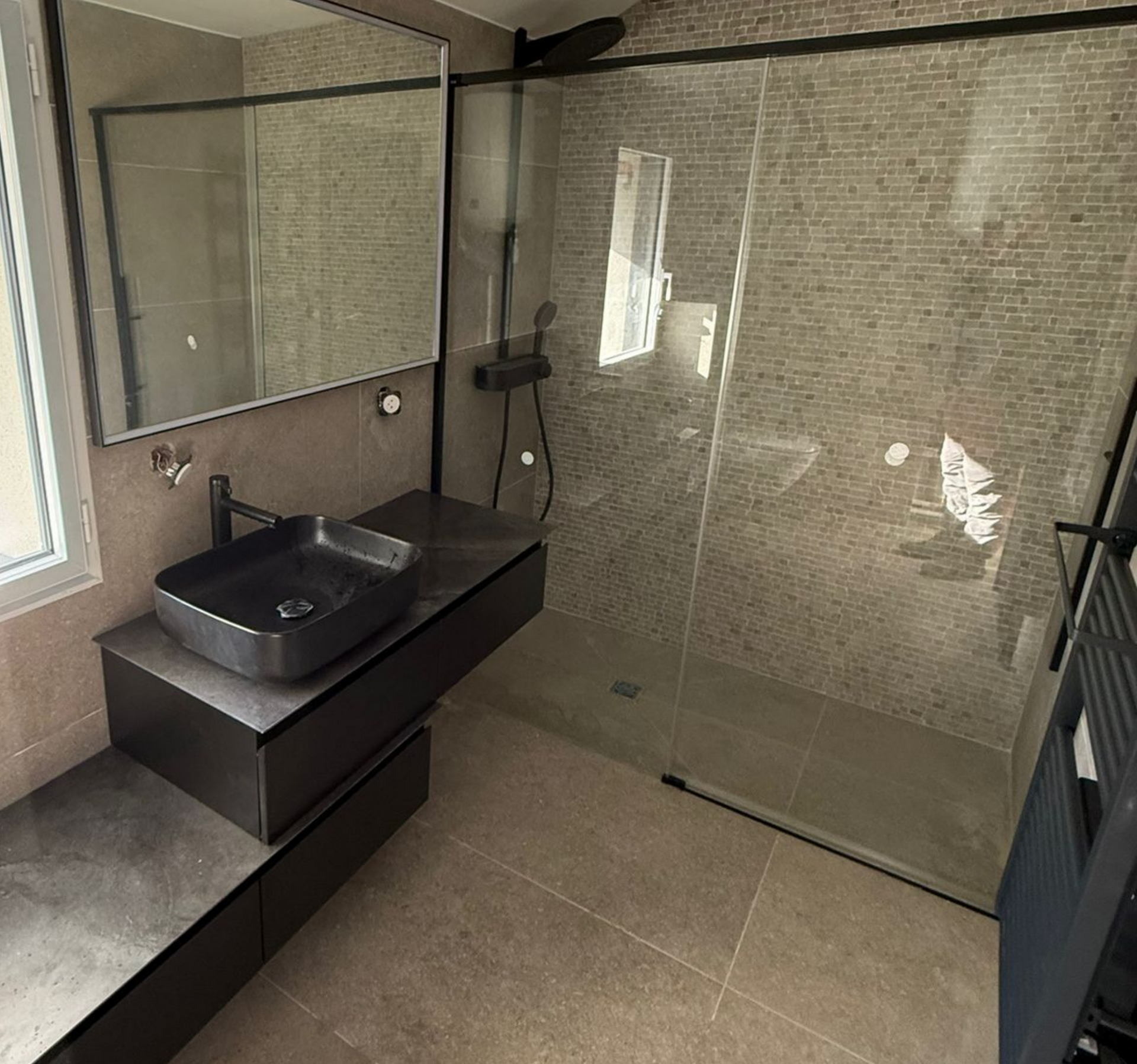 Salle de douche noire moderne avec une vanité et radiateur