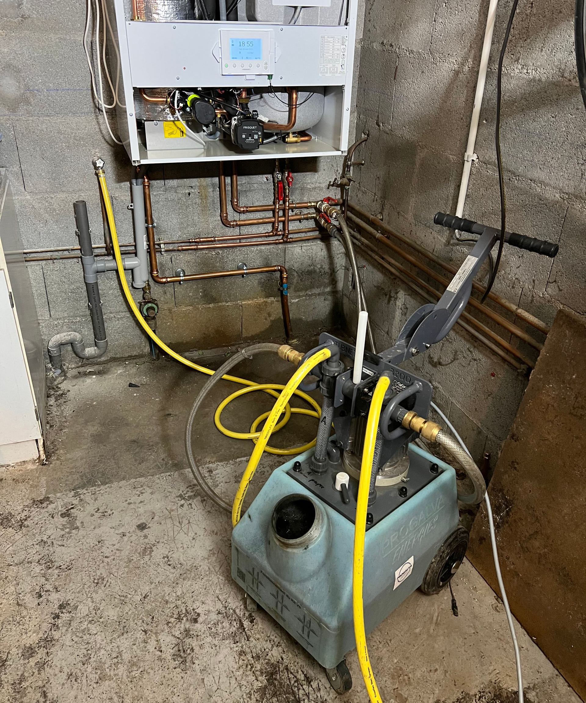 Installation d'une chaudière à gaz avec détartrant, à l'intérieur d'une buanderie.