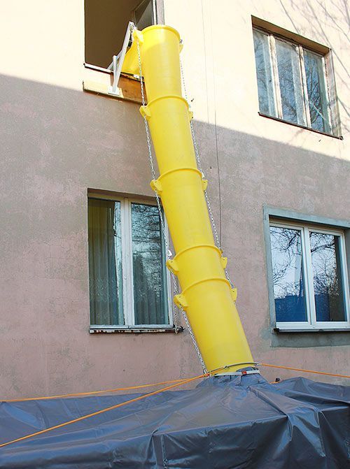 Un tubo amarillo está conectado al costado de un edificio.