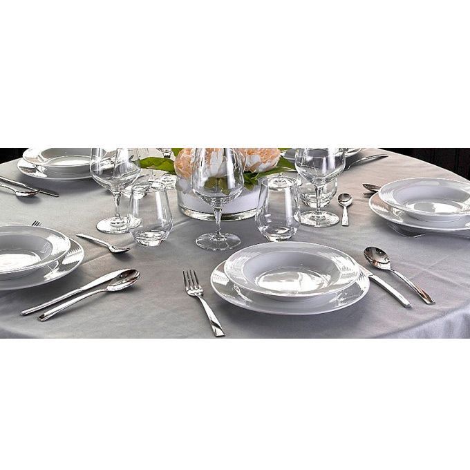 Una mesa puesta con platos, cubiertos, vasos y un jarrón de flores.