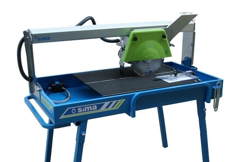 Sierra para baldosas azules y verdes, cortando baldosas sobre una mesa.