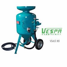 Una máquina de chorro de arena con ruedas y una manguera conectada a ella.