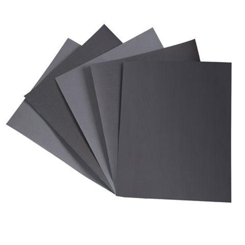 Un abanico de hojas de papel negras sobre un fondo blanco.