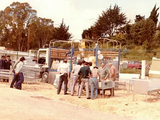 Un grupo de personas está de pie delante de un camión.