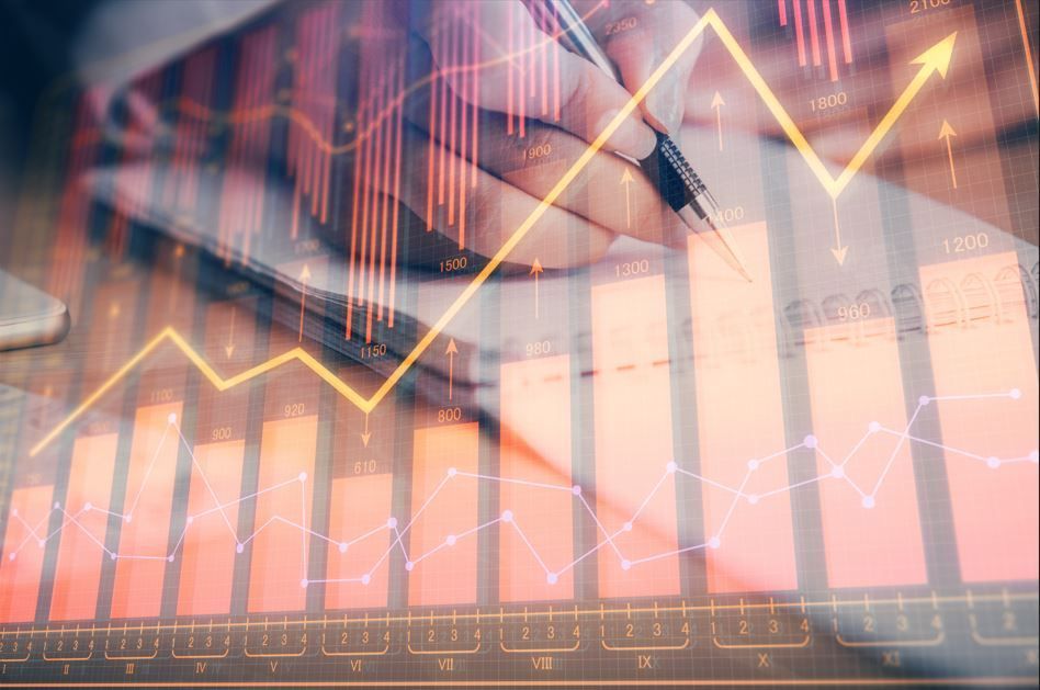 Persona escribiendo en un cuaderno con superposición de gráficos financieros y una flecha con tendencia ascendente.