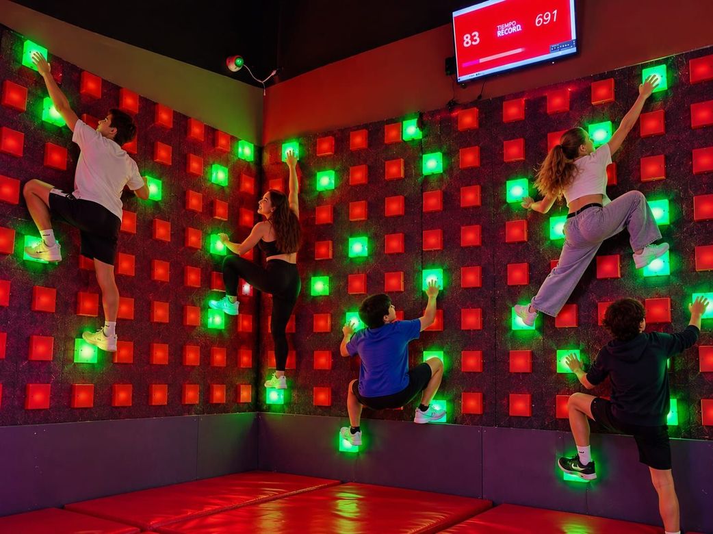 Juego de tiro de baloncesto de interior con rampa negra, dos canastas y un letrero de «All Access Diversion» en una pared azul.