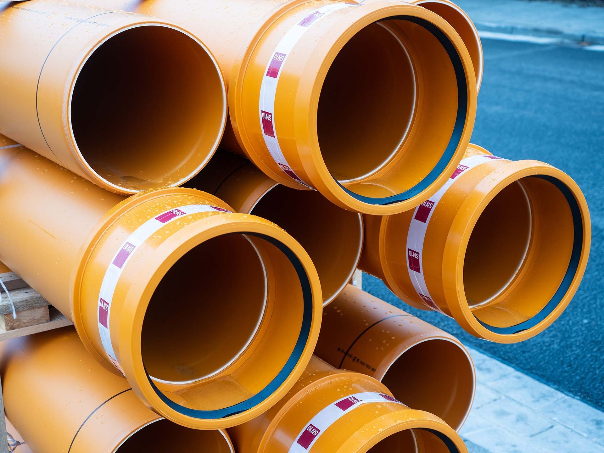 Ein Bündel orangefarbener Rohre sind übereinander gestapelt